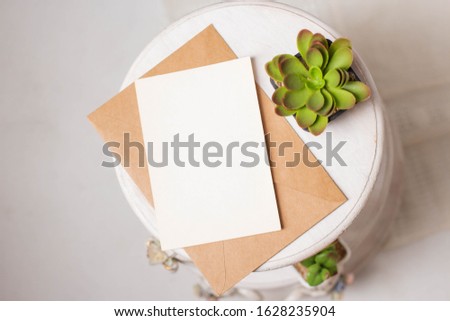 card mockup with plant in the pot in wooden round table. minimal invitation