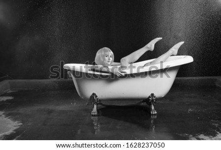 beautiful girl with orange hair posing in a white bath on a red-blue background