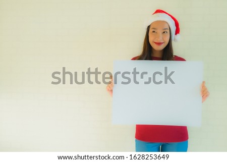 Portrait beautiful young asian women wear santa christmas hat show blank white board card with copy space