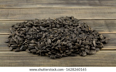 A pile of sunflower seeds on a wooden table close-up.