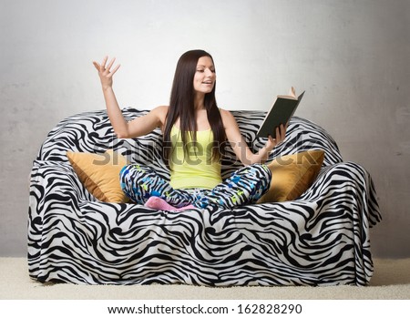 Inspired girl sitting on the sofa and reciting a poem Royalty-Free Stock Photo #162828290