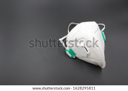 N 95 respirator dust mask for protect PM 2.5 White medical mask isolated. Face mask protection against pollution, virus, flu and covid19 

A dark background Royalty-Free Stock Photo #1628295811