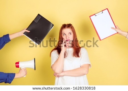 Thoughtful. Caucasian young woman's portrait on yellow studio background, too much tasks. How to manage time right. Concept of office working, business, finance, freelance, self management, planning.
