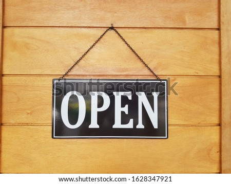Label "open sign" on wooden door