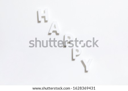 The white letters of the alphabet HAPPY placed on a white background