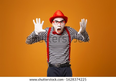 Surprised mime in red hat, white gloves and striped t-shirt on blank orange background