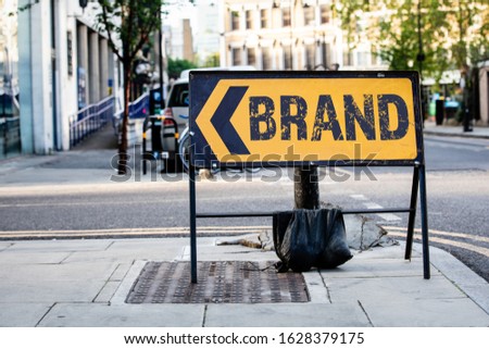 Brand. Business, logo, name, advertising and marketing concept. Yellow diversion road sign in a UK city street
