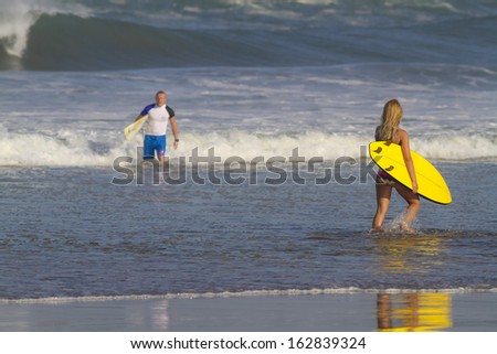 surfer couple on beach.