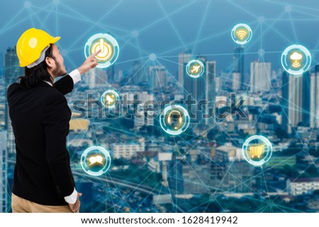 The double exposure of of a young Asian engineer and with a skyscraper and an icon of trade and transportation showing the speed of communication between the seller and the client's company.