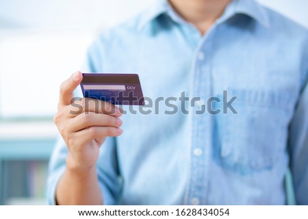 Man hand holding back credit card wear shirt Royalty-Free Stock Photo #1628434054