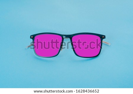 Pink glasses on blue background. Minimal concept of summer vacation