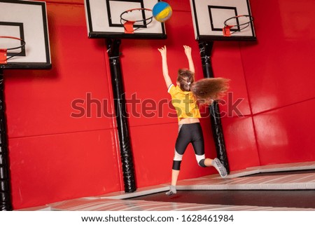Happy child girl playing basketball and having fun in jump park