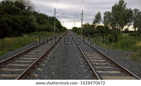 Double track electrified railway with concrete railroad ties on a cloudy summer morning in Hungary