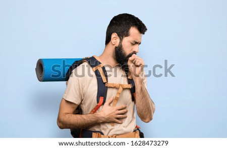 Hiker man is suffering with cough and feeling bad over isolated blue background
