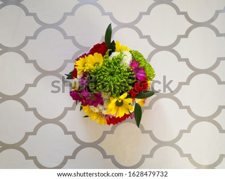 Bright colorful spring flowers bouquet shot from above on gray and white patterned surface. Top view. Mother's Day, Valentine's Day, greeting card.