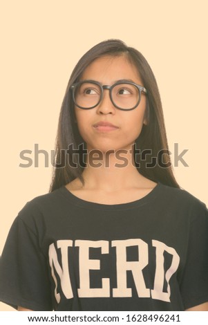 Close up of young Asian teenage nerd girl thinking
