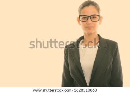 Studio shot of young beautiful businesswoman wearing eyeglasses