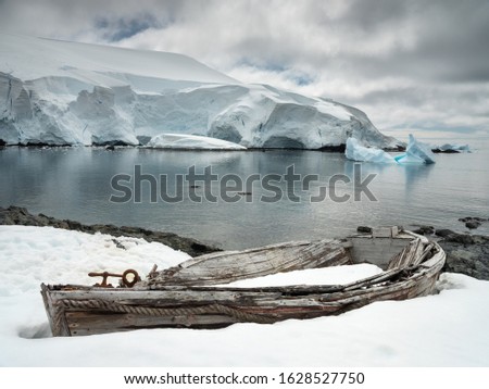 view to old boat on the snowed coast and glacier