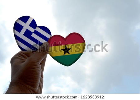 Hand holds a heart Shape Greece and Ghana flag, love between two countries