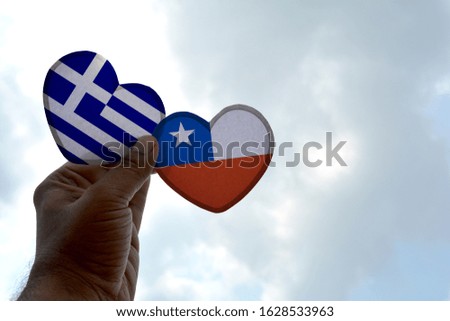 Hand holds a heart Shape Greece and Chile flag, love between two countries