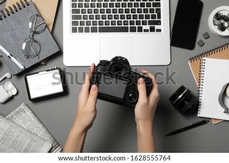 Journalist with camera at grey table, top view