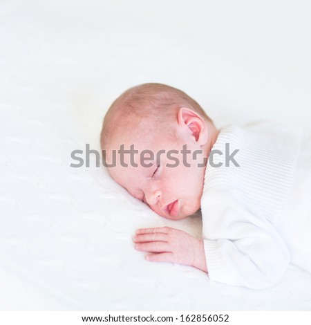 Adorable newborn baby sleeping on a white blanket