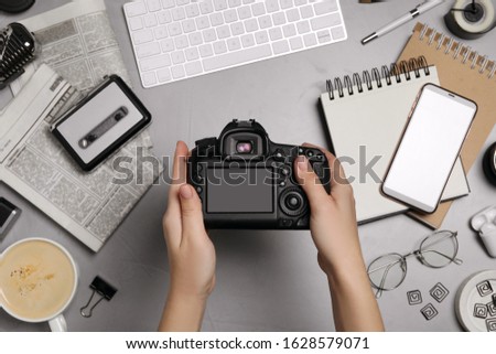 Journalist with camera at grey table, top view