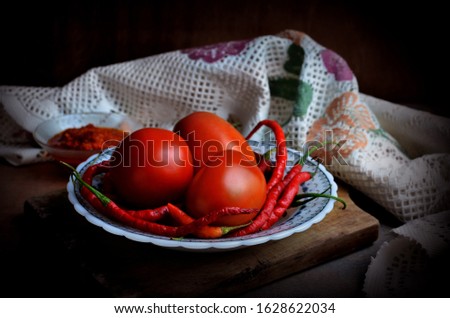 Tomatoes and red chilli on a chopping board