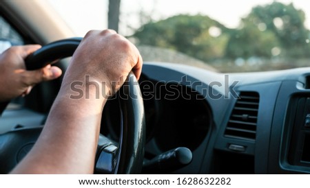 Photo of the hand is controlling the steering wheel.