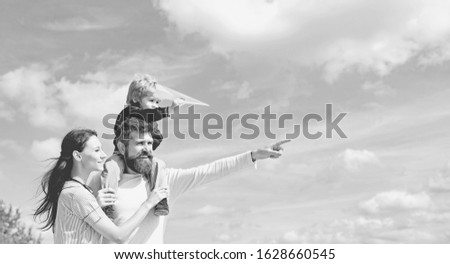 Happy family - mother, father and son on sky background in summer. Dream of flying. Happy family father and child on meadow with a kite in the summer on the nature