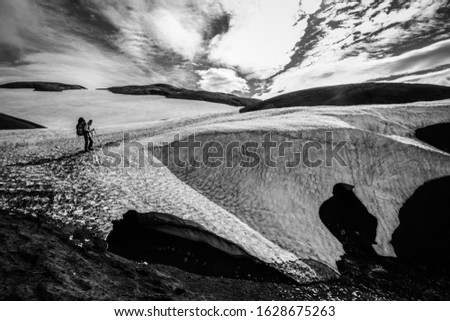 Wonderful landscape in Iceland (Europe) Travel to the reserve. Northern nature, beautiful views. Black and white art. Lonely man with a backpack. Snow, glacier, volcanic ash.