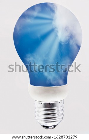 Lightbulb with sun rays in the blue sky