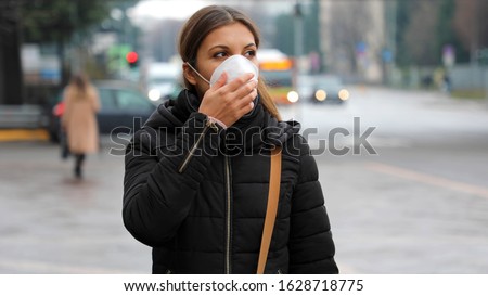 COVID-19 Pandemic Coronavirus Woman in city street wearing protective face mask for spreading of disease virus SARS-CoV-2. Girl with protective mask on face against Coronavirus Disease 2019. Royalty-Free Stock Photo #1628718775