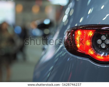 Closeup backside light of car gray color shiny and blur background in motor show event transportation concept