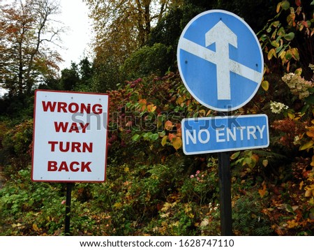 'No Entry' and 'Wrong Way Turn Back' road signs. 