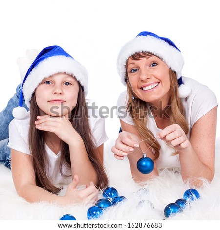 Girl and woman in Santa caps. Isolated white background