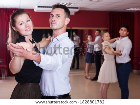 Portrait of positive people dancing together slow ballroom dances in pairs