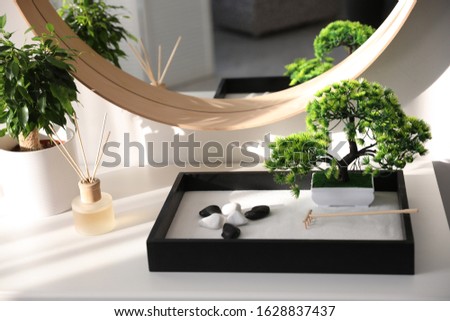 Beautiful miniature zen garden on white table indoors Royalty-Free Stock Photo #1628837437