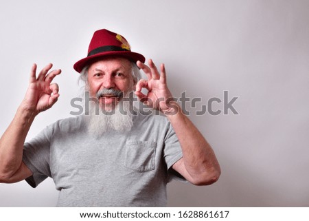Happy old man with a big smile.
Smiling man wearing a red fedora giving a double OK sign.
Mature gentleman making the OK sign