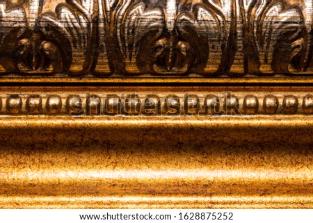 vintage wooden frame in gold paint curved with patterns close up