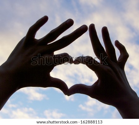 love shape hand silhouette in sky