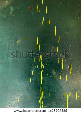 Yellow paint splashes on green background.