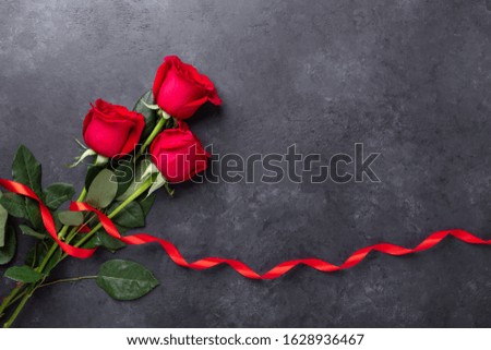 Red rose flowers bouquet on black stone background Valentine's day greeting card Copy space Flat lay - Image
