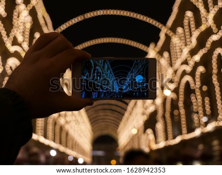 Hand of man taking the photo of night scene by smartphone. Focus on touch screen. male hand using smartphone to taking photo of night light cityscape, lifestyle and technology concept. 