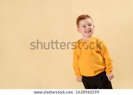 Fashionable little Boy jeans.stylish kid in yellow blazer. Fashion Children. bright pullover and black jeans. on a lighte background in the studio .Copy space