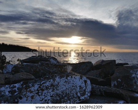 Sunset on the lake with rocks in the foreground