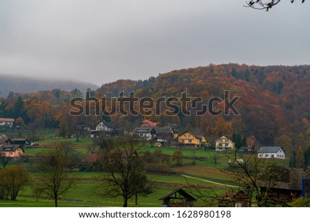 Fall in the alpine village, hills and mist