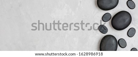 Top view of hot spa stones set for massage treatment on gray concrete background with copy space. Elegant and luxury spa. Flat lay, overhead, mock up, template. Health and beauty care concept