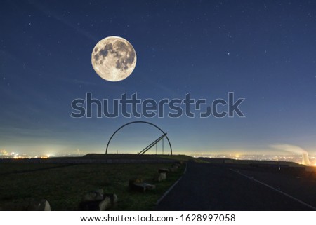 Horizon observatory on Halde Hoheward in Herten in night view with moon, phases of the lunar eclipse and the globe as graphic elements in composition