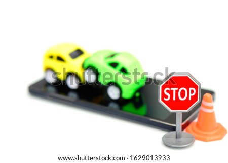 Macro shooting of stop sign in front of blur green and yellow car over blurred smartphone background isolated on white. Safety life do not use smartphone when you drive your car. Safety design concept
